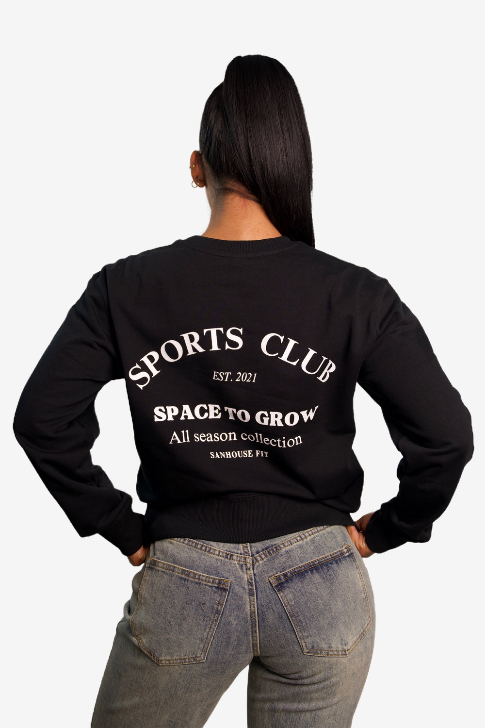 Back view of model wearing a black sweatshirt for women. A casual wear collection from Sanhouse Fit.