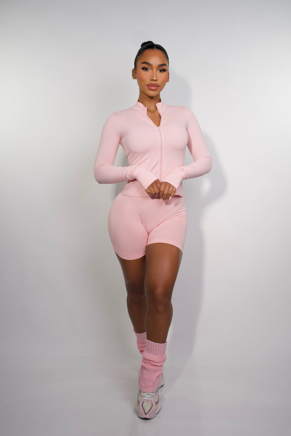 Front view of model wearing a butt scrunch, women biker shorts in soft pink color.