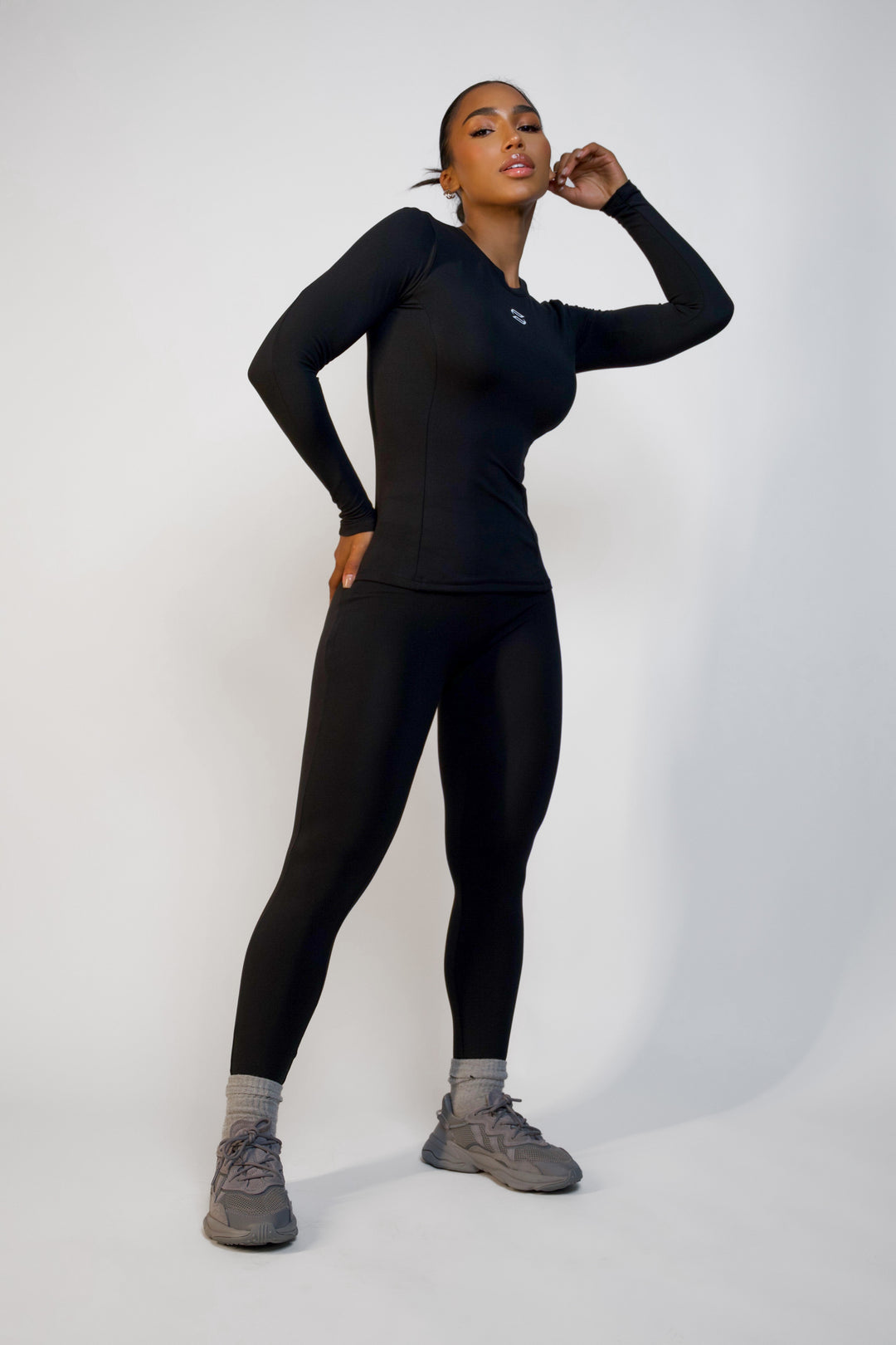 Full body front view of model wearing black long sleeve workout top from Sanhouse Fit
