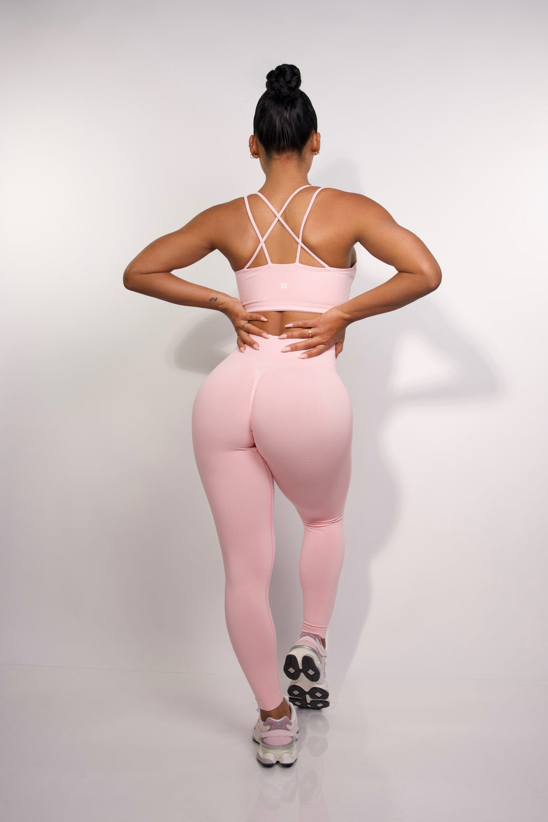 Full body back view of model wearing pink sports bra for women from Sanhouse Fit.