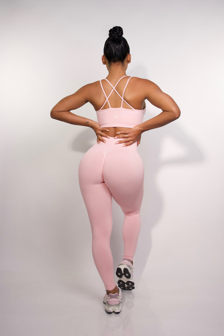 Full body back view of model wearing pink sports bra for women from Sanhouse Fit.